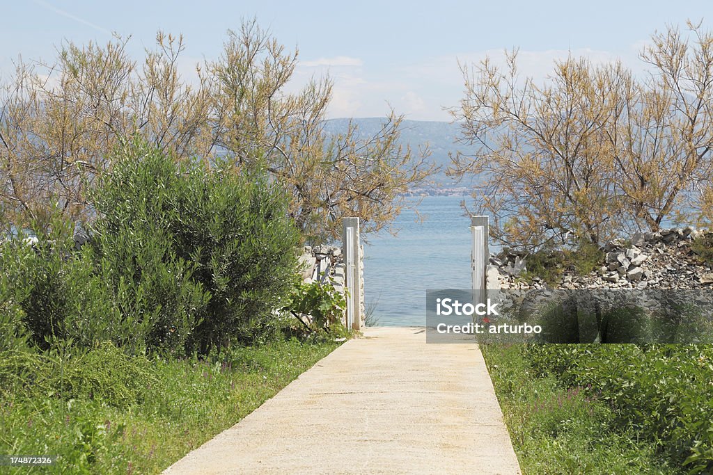 Zaun mit offenem Tor zu Türkis Mittelmeer Ozean Trogir Kroatien - Lizenzfrei Hausgarten Stock-Foto