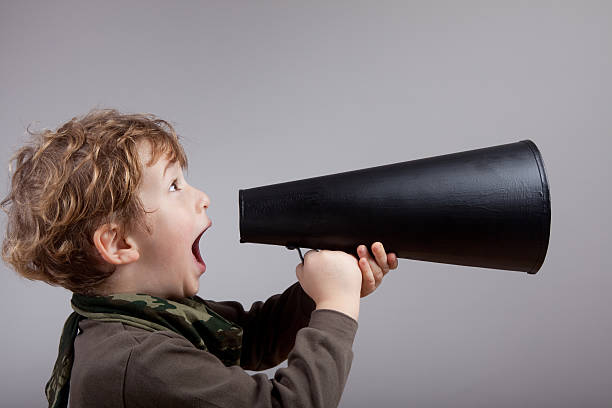 istock Cute little boy shouting on old fashioned megaphone 174872379