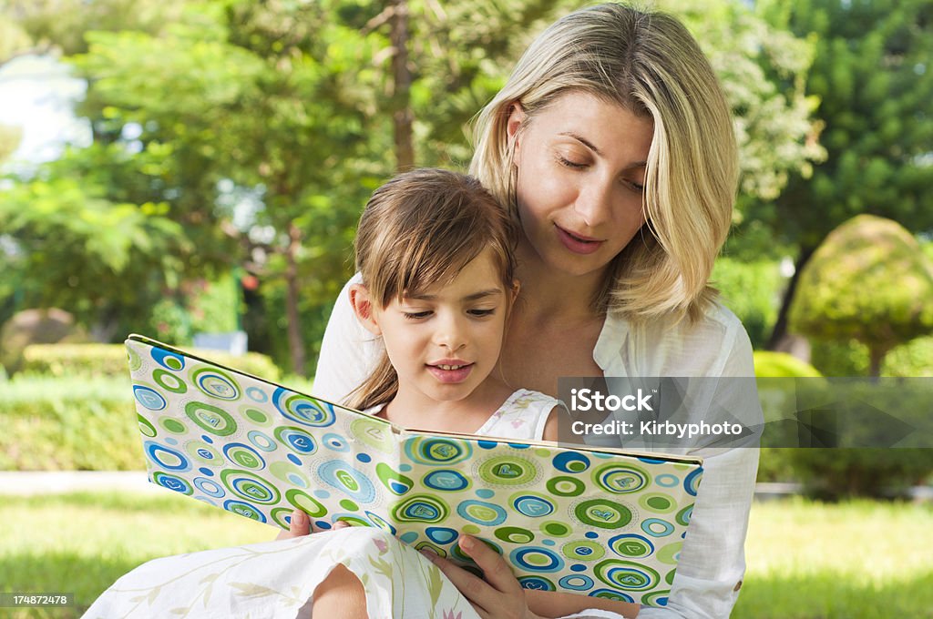 Reading in the park Mother and daughter reading a book in the park. AdobeRGB photo. 4-5 Years Stock Photo