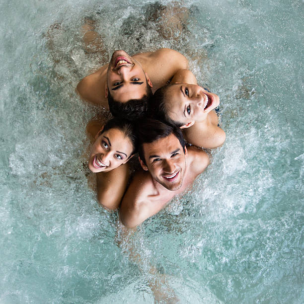 grupo de pessoas na banheira de hidromassagem - couple hot tub spa treatment health spa - fotografias e filmes do acervo