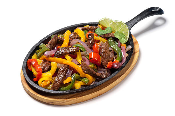 Beef fajitas with bell peppers on a plain white background Sizzling skillet of beef fajitas! fajita photos stock pictures, royalty-free photos & images