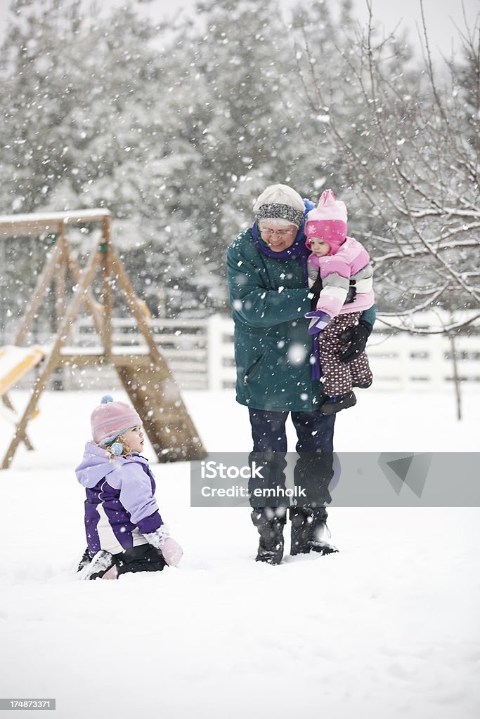 Filles jouant dans la neige avec ta grand-mère. - Photo de 12-17 mois libre de droits