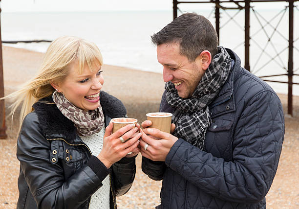 istock Couple enjoying hot drinks outdoors on windy day 174873443
