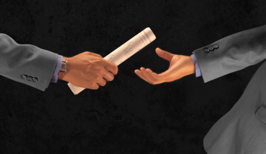 Business people hands passing newspaper as a baton