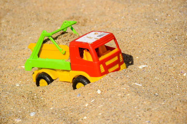 istock Children's toy car, colorful plastic lorry on beach sand. 1748744025