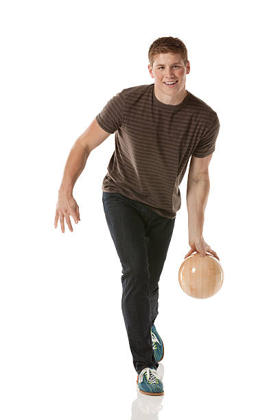 привлекательный молодой человек играет с шар для боулинга - bowling isolated sportsman vertical стоковые фото и изображения