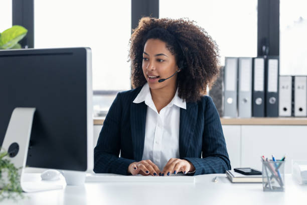istock Elegant business woman working while talking with earphone at modern office 1748748614