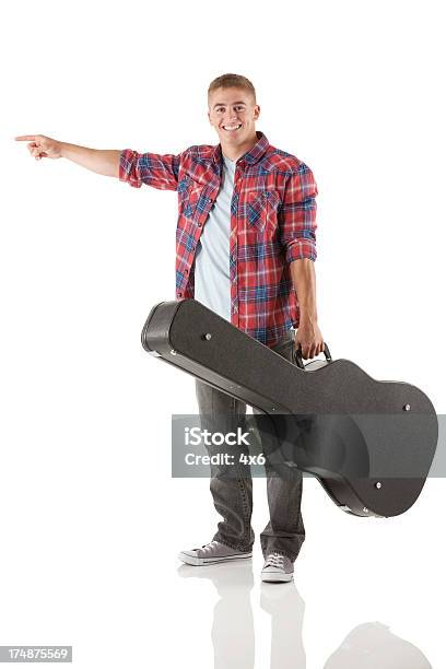 Happy Street Musician Holding A Guitar And Pointing Stock Photo - Download Image Now