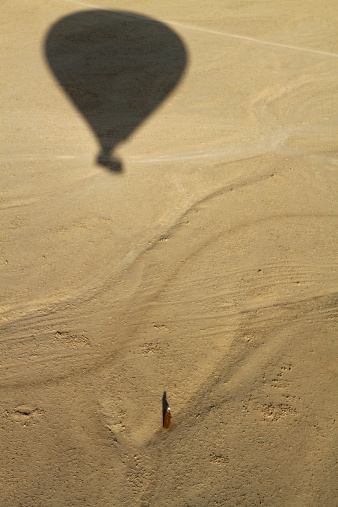 A hot air balloon descends to the Sahara Desert in the Valley of the Kings near Luxor