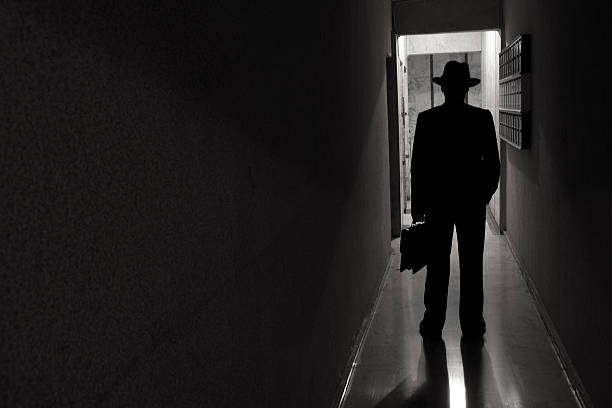 istock Man with hat standing in dark spooky entrence hall 174876055