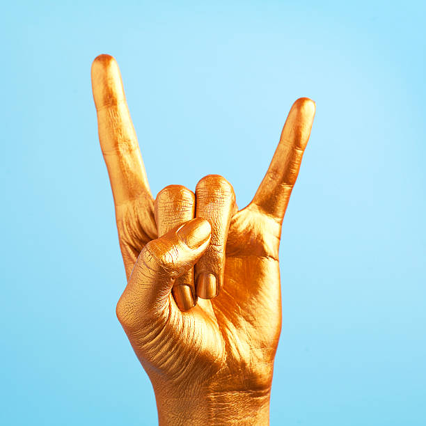 gold painted hand making sign of the horns