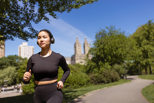 Cute multiracial girl jogging in Central Park, NYC