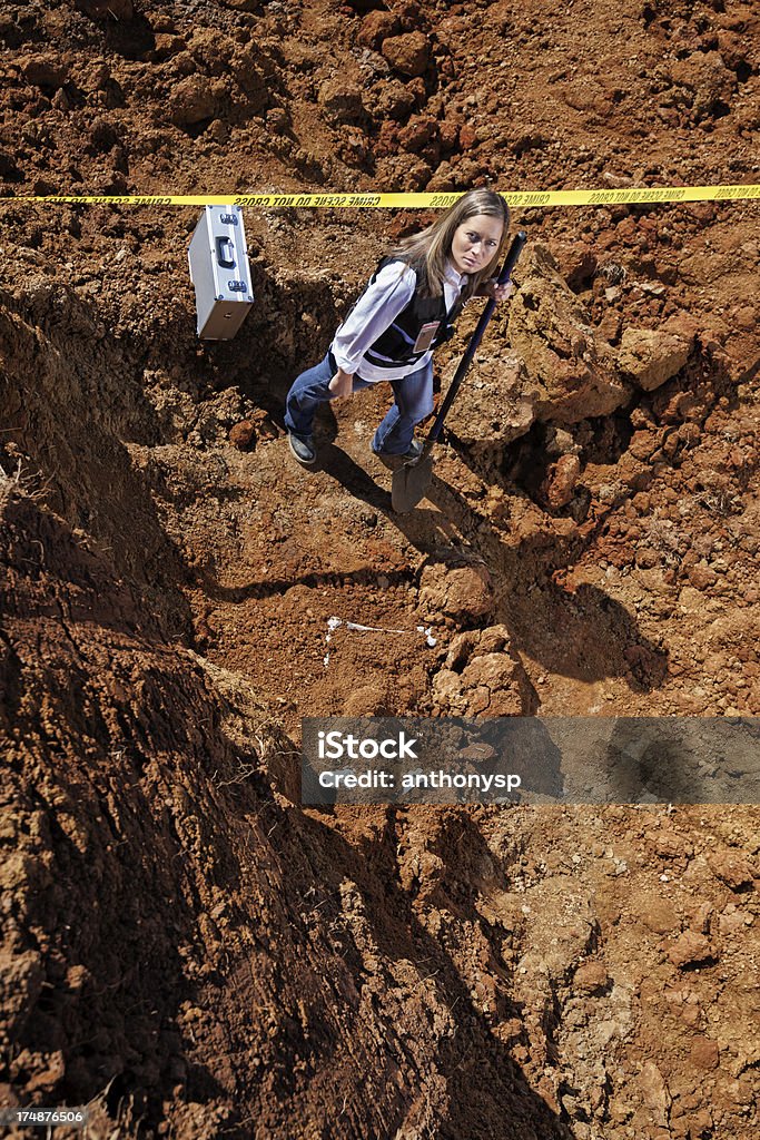 body dump Female crime scene investigator removing bones from dirt. Adult Stock Photo