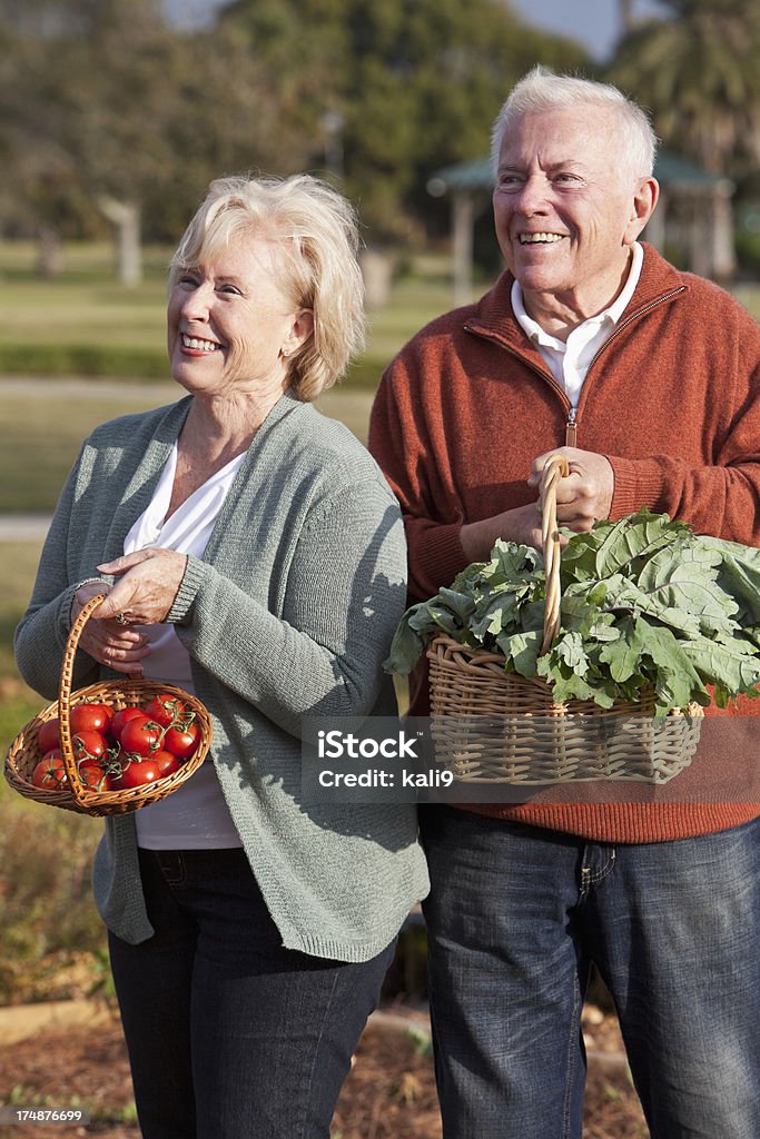Pareja Senior con verduras probar desde jardín - Foto de stock de 60-69 años libre de derechos