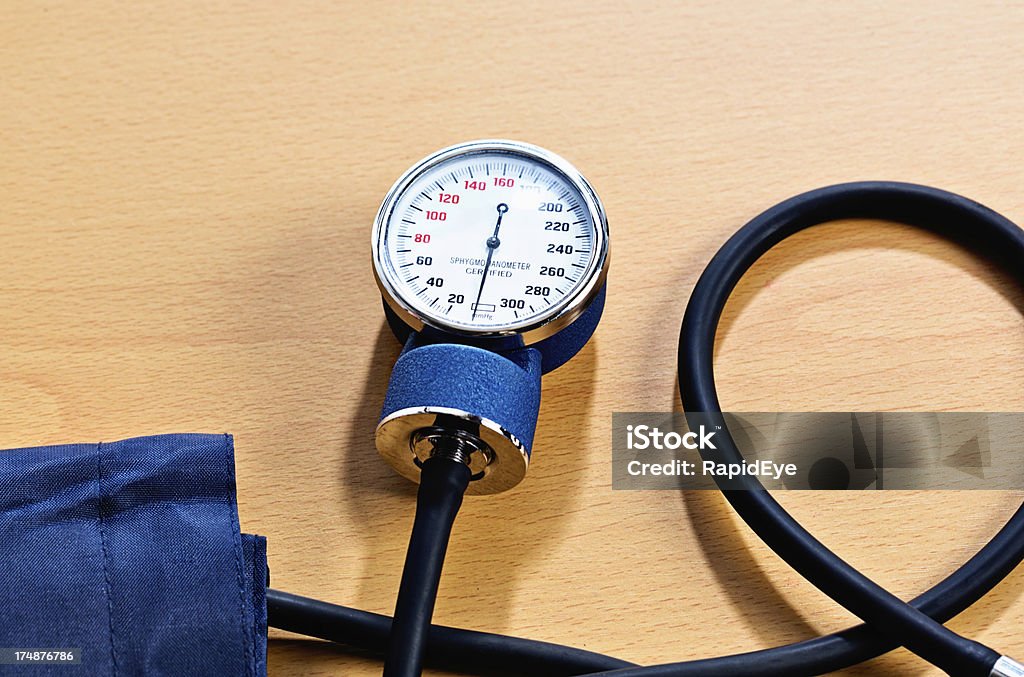 Blood pressure checks are vitally important - have them regularly! Have your blood pressure checked regularly - it's vital! Blood pressure gauge on wooden desk. Blood Stock Photo