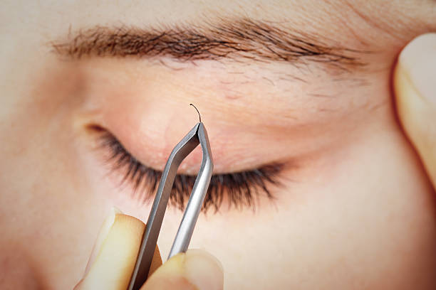 istock Young Woman Tweezing Her Eyebrows 174876915
