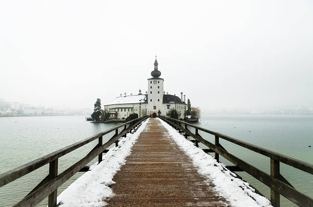 Bridge to Seeschloss Ort Wonderful capture of the old church Seeschloss Ort in Gmunden on a cold and snowy January morning. The area of Salzkammergut is a world heritage site. The Seeschloss was also royal residence of Adam von Herberstorff, who died September 1629 in this building. Since 1995, the Seeschloss is a public building. seeschloss stock pictures, royalty-free photos & images