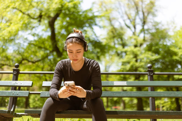 Girl checking jogging mobile app after jogging stock photo