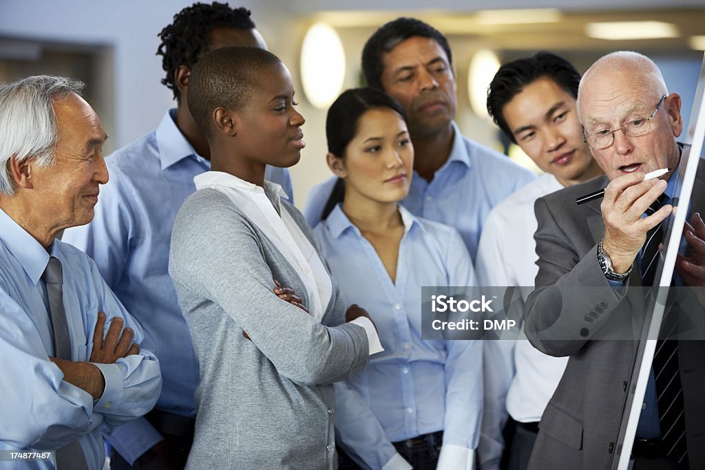 Uomo d'affari dando presentazione per il suo team - Foto stock royalty-free di Lavoro di squadra