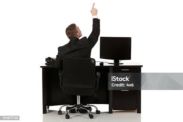 Geschäftsmann Sitzen Am Schreibtisch Mit Dem Finger Zeigen Nach Oben Stockfoto und mehr Bilder von Eine Person