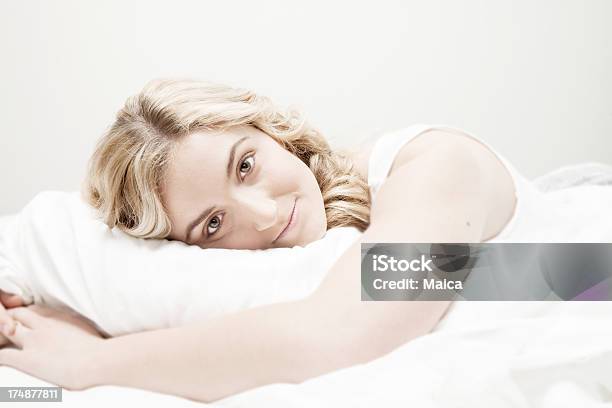 Hermosa Mujer Lying On Bed Foto de stock y más banco de imágenes de Adulto - Adulto, Adulto joven, Almohada