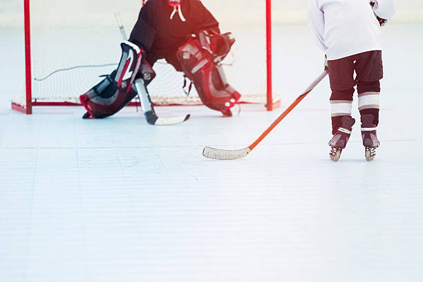 Two kids from little league training roller hockey indoor.