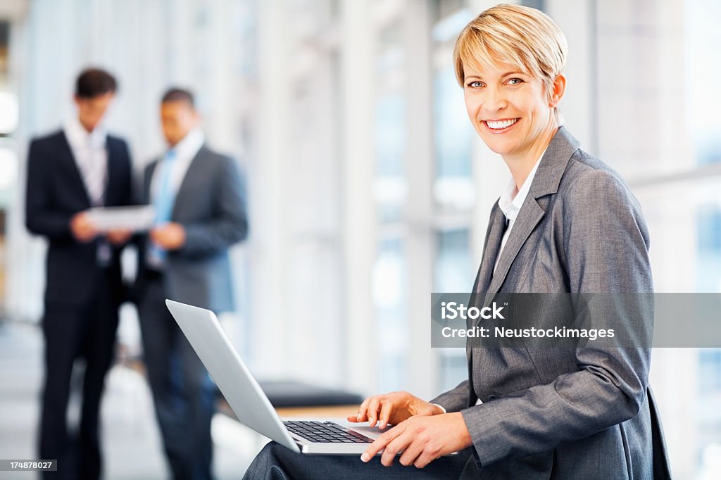 Mujer de negocios usando computadora portátil - Foto de stock de 20 a 29 años libre de derechos