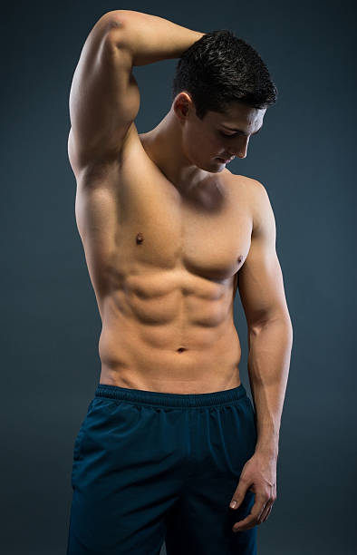 スポーティな若い男性、灰色の背景 - sex symbol the human body male abdomen ストックフォトと画像