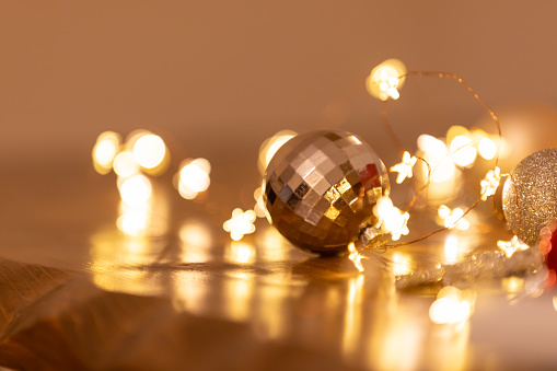 Golden christmas lights and bokeh on dark wood. Blurred lights background for your advent decorations. Space for text.\