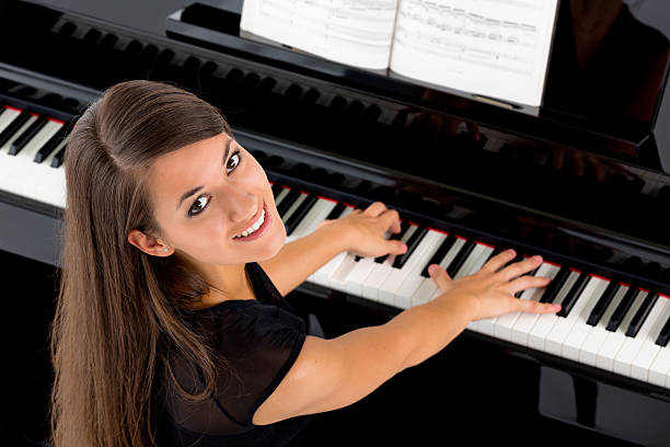 istock beautiful female piano player 174879183