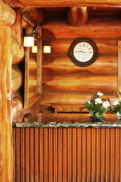 Upscale luxury log cabin style hotel rustic interior decor with granite countertop, mirror, lighting and clock at front desk.  Flagstaff, Arizona, 2012.