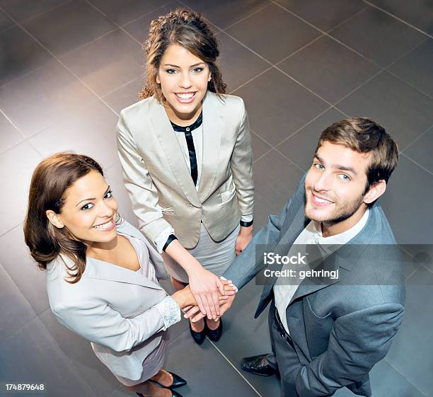 Sonriendo Los Empresarios Huddled Juntos Foto de stock y más banco de imágenes de 20 a 29 años - 20 a 29 años, Abrazo de grupo, Acuerdo