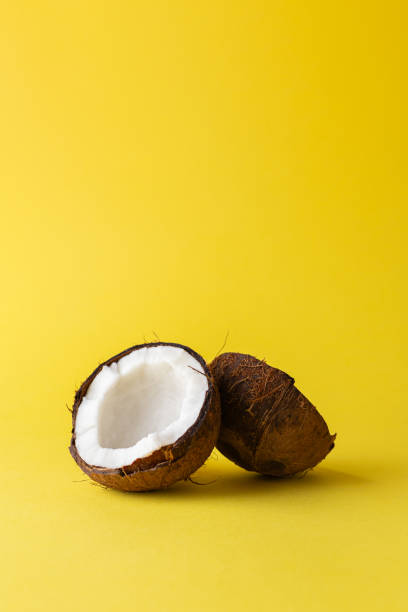 istock Coconut halves isolated on yellow background. Space for copy 1748829759