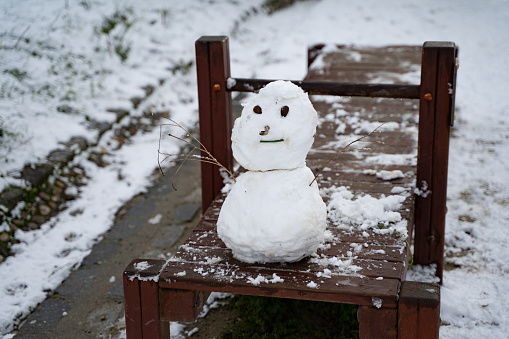 Small child snowman in park on winter day