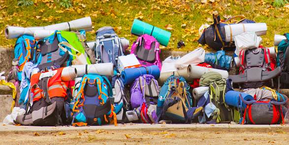 Heap of pilgrim backpacks on ground - backpacking. Arrival from Camino de Santiago pilgrimage route.  Santiago de Compostela, Galicia, Spain.