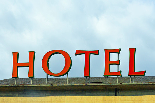 Large hotel sign on top of building, rooftop , cloudy sky in the background. Santiago de Compostela, Galicia, Spain.