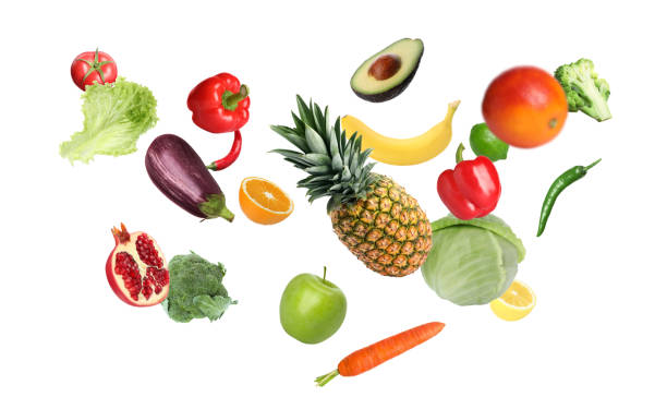 Many fresh vegetables and fruits falling on white background