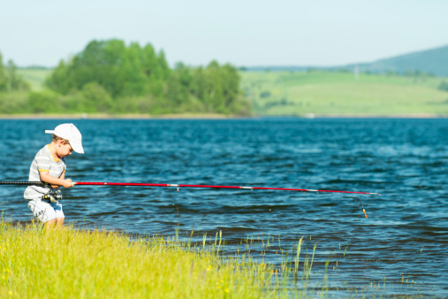 Little boy trying to handle fishing rod