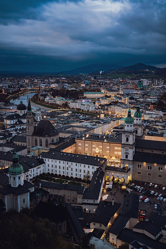 Aerial panoramic winter view of historic Salzburg, Austria, with Salzach river, Christmas markets and dramatic sky - Medium - Portait