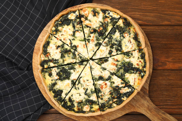 istock Delicious homemade spinach quiche on wooden table, top view 1748934875