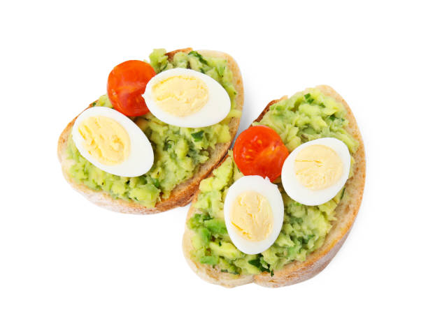 istock Delicious sandwiches with guacamole, eggs and tomatoes on white background, top view 1748937092