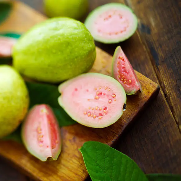 ripe guava fruits on a vintage metal plate and knife