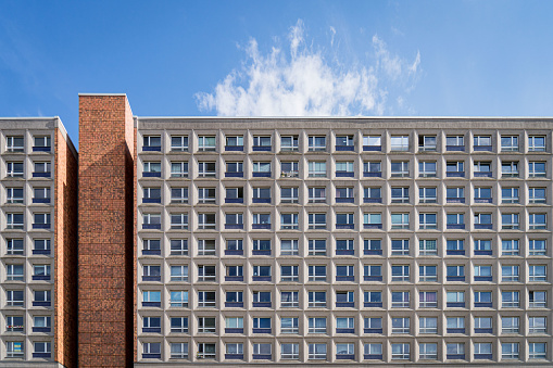 Flat on view of brutalist concrete communist-era east berlin apartment block on sunny day