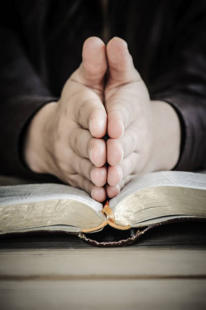 istock Woman praying with her hands on the Bible. 174894400