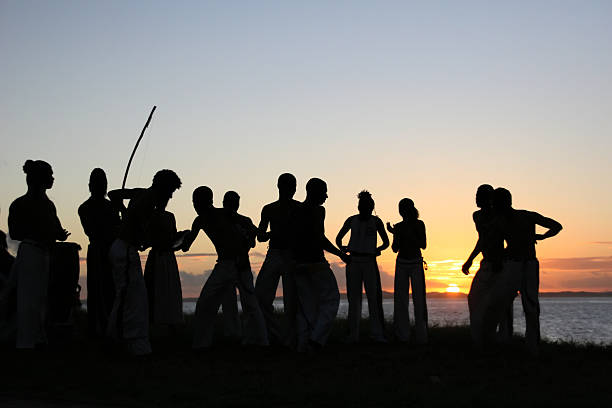 grupo de pessoas de capoeira praticando ao pôr-do-sol - handcarves sports and fitness arts and entertainment people - fotografias e filmes do acervo