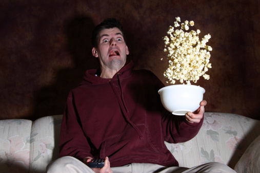 Man loses his popcorn because he gets startled with fright.Add a nice blue overlay and he's at the movie...eeek!