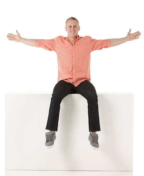 Man sitting on the ledge with arms outstretched