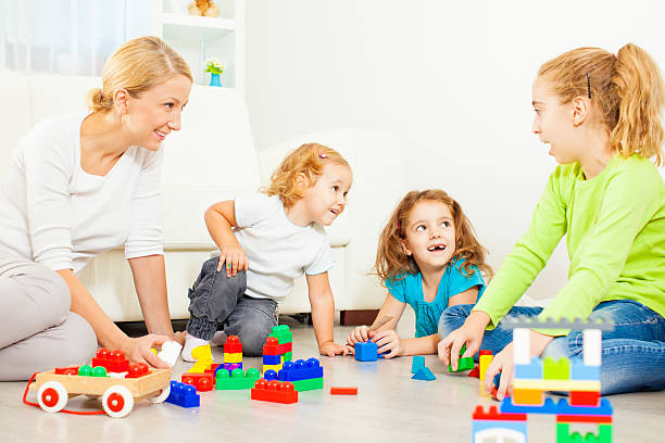 mãe e crianças brincando com blocos de cor em casa. - craft block togetherness community - fotografias e filmes do acervo