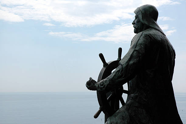 A statue looks out over the ocean.