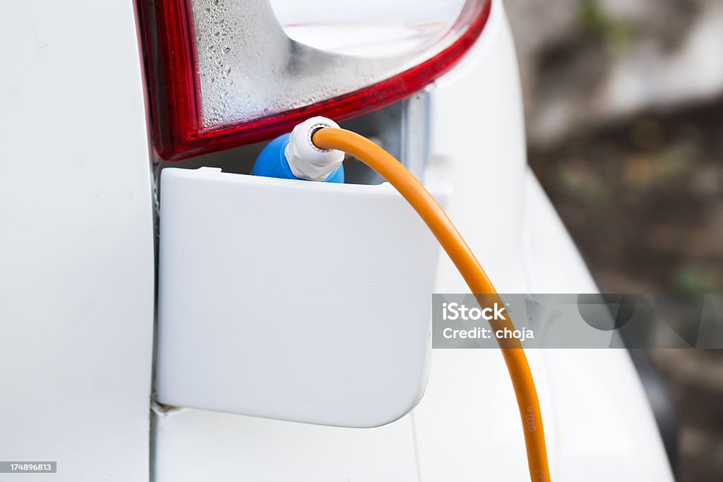 Primo piano di un'auto elettrica spina e ricaricare - Foto stock royalty-free di Automobile